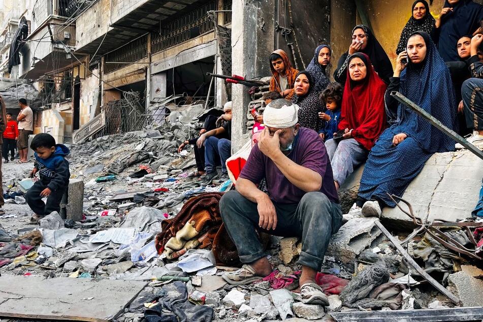 An injured man reacts while sitting on the rubble of a building hit by an Israeli strike in Beit Lahia, in the northern Gaza Strip, on October 29, 2024.