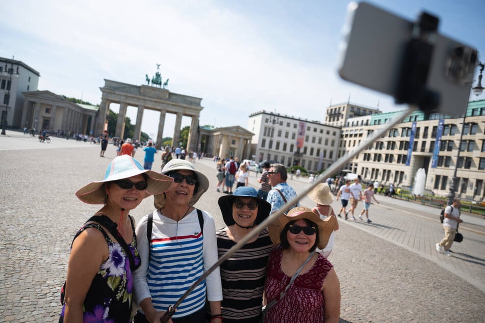 Vier Touristinnen machen ein Selfie am Brandenburger Tor, das bei den vielen Berlin-Besuchern sehr beliebt ist. (Archivfoto)