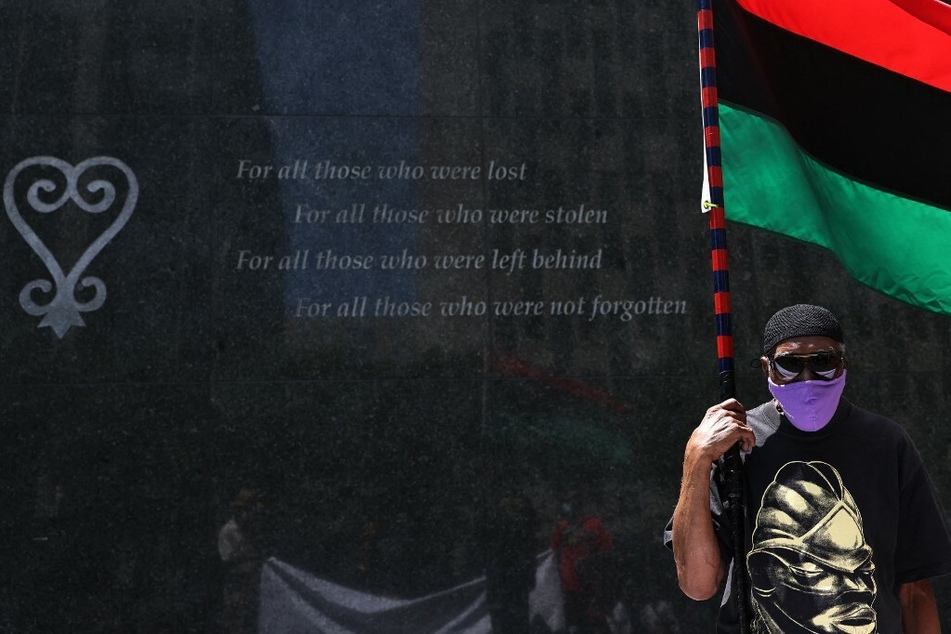 A protesters holds a Pan-African flag during a rally for reparations in New York City in July 2021.