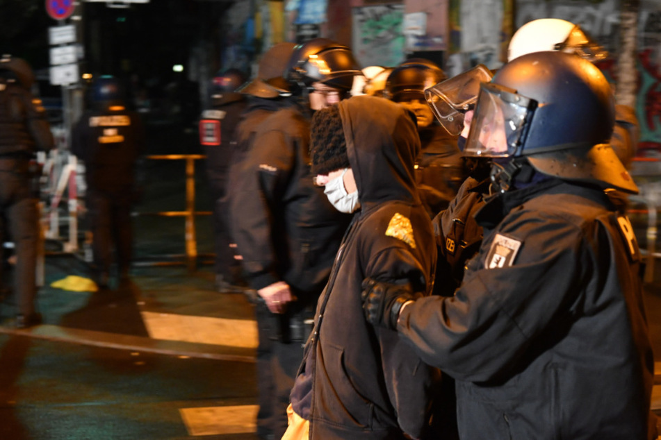 Polizisten führen in der Rigaer Straße einen Demonstranten ab.