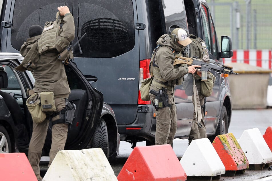 Schwer bewaffnete Spezialkräfte der Polizei bereiten sich am Flughafen auf einen Einsatz vor.