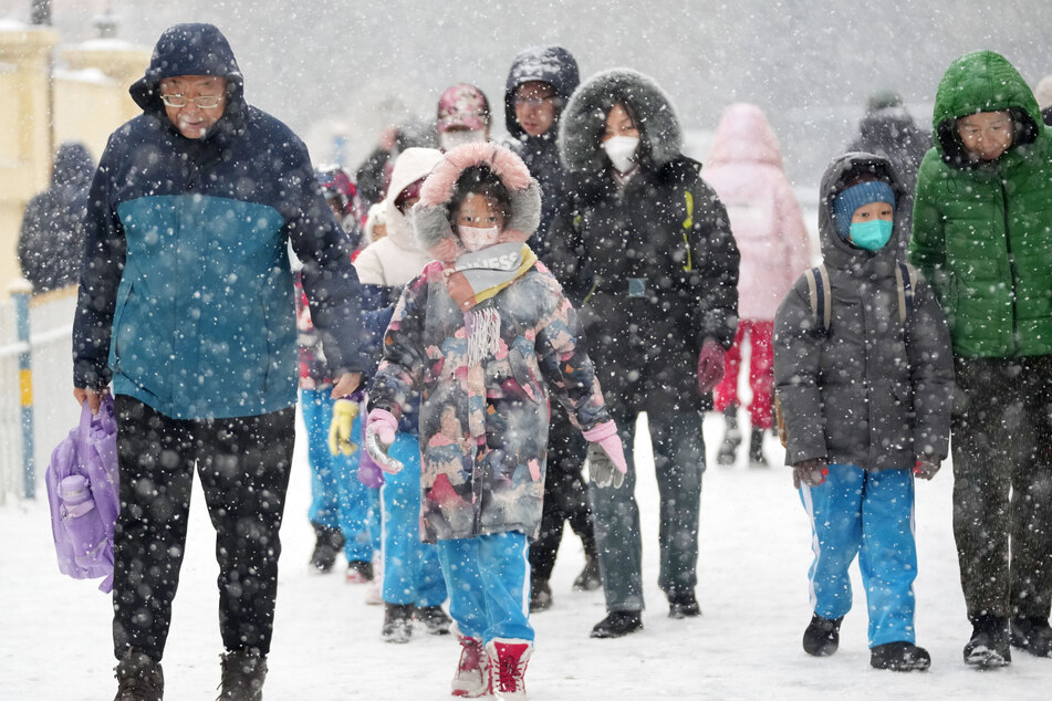 Eltern bringen ihre Kinder bei Schneefall zur Schule. Lehrer haben Erziehungsberechtigte bereits aufgefordert, Kinder mit Symptomen zwingend daheim zu lassen.