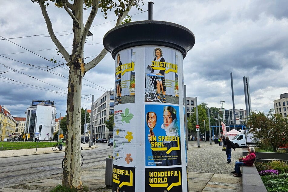 Oben an der Litfaßsäule steht der Rechtsanwalt plakativ am Bügelbrett.