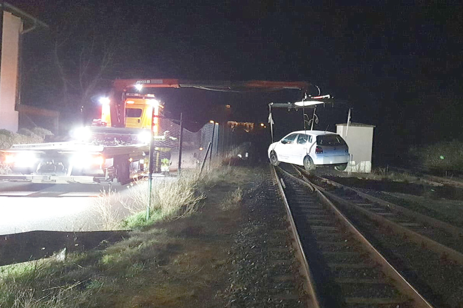 Der VW wird von einem Abschleppdienst von den Bahnschienen geholt.