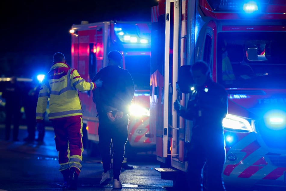 Ein Tatverdächtiger wird von den Einsatzkräften zu einem Rettungswagen gebracht.