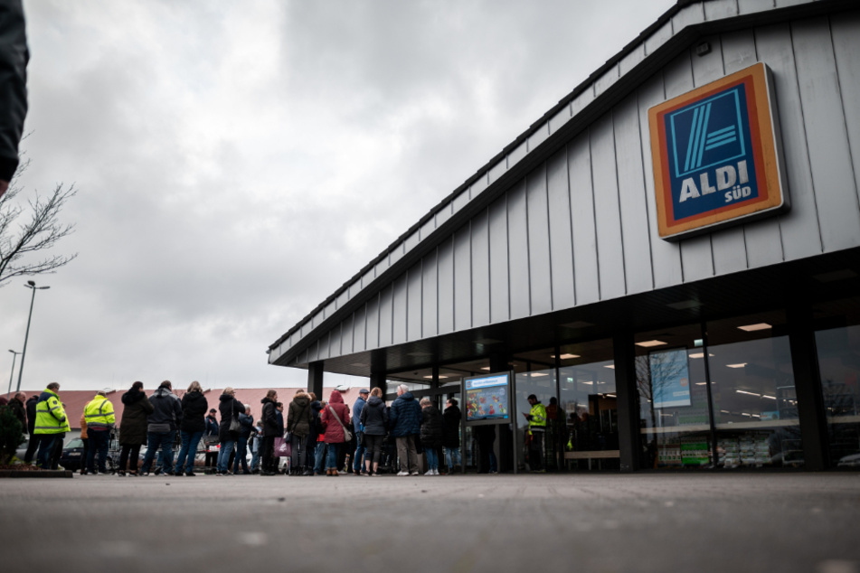 Vor einem Aldi-Geschäft steht eine Warteschlange.
