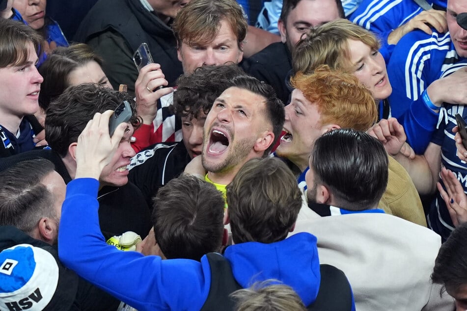 Was für ein Bild: HSV-Keeper Daniel Heuer Fernandes (M.) badet im Meer der frenetischen Fans.