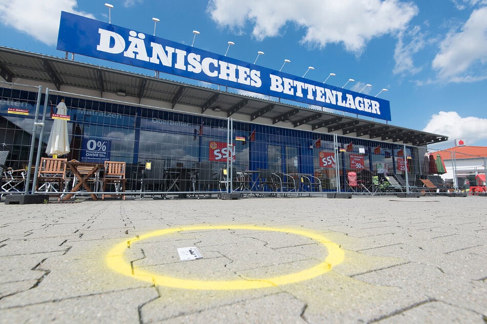 Eine Spur ist nach dem Überfall auf einen Geldtransporter auf dem Parkplatz vor einer Filiale des Dänischen Bettenlagers in Cremlingen markiert. (Archivbild)