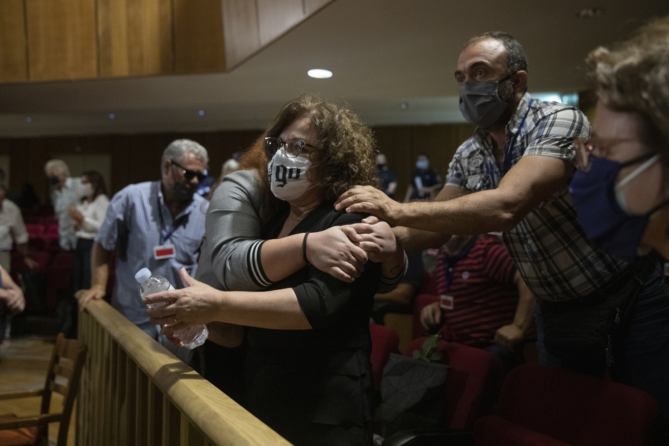 Magda Fyssa, Mitte, die Mutter des verstorbenen griechischen Rap-Sängers Pavlos Fyssas, der 2013 von einem Anhänger der rechtsextremen Golden Dawn-Partei erstochen und getötet wurde, was zu einer Razzia gegen die Partei führte, feiert unmittelbar nach der Verkündung des Urteils eines Gerichts.