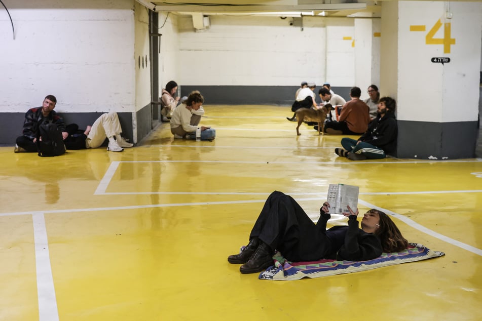 Menschen suchen Schutz in einer Tiefgarage, nachdem Alarm wegen ankommender Raketen aus dem Iran ausgelöst wurde.