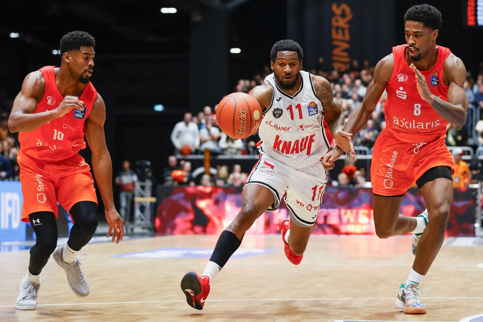 Victor Bailey Jr., Nelson Phillips (Würzburg) und William Christmas kämpfen um den Ballbesitz.