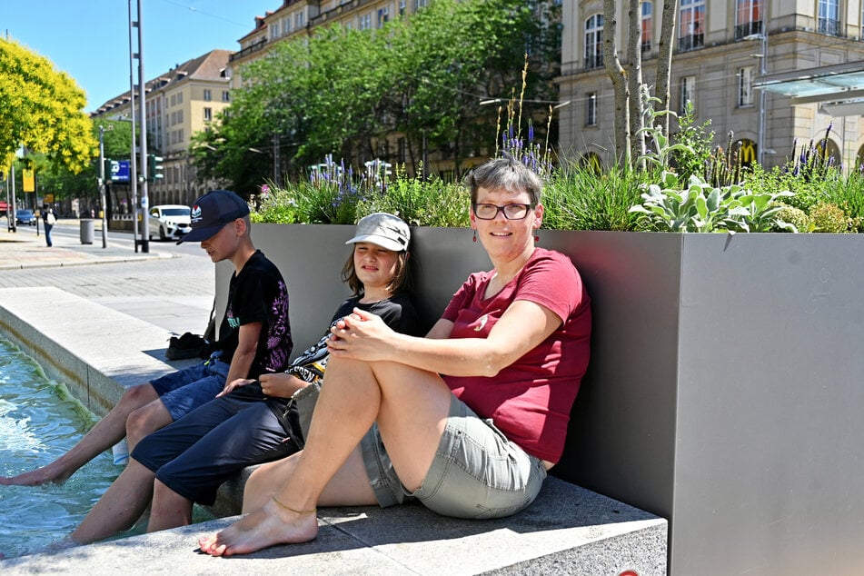 Schulsozialarbeiterin Franziska Schmidt (40) quetscht sich mit ihren Schülern Florian (13) und Oskar (12) in das bisschen Schatten.