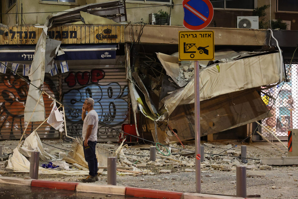 Ein Mann steht vor einem beschädigten Geschäft in Tel Aviv, nachdem es am 7. Oktober von einer Rakete aus dem getroffen wurde, die palästinensische Militante aus dem Gazastreifen abgefeuert hatten.