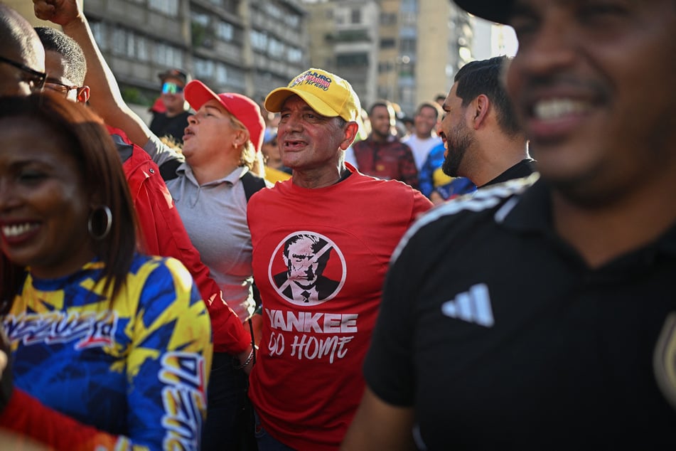 A supporter of Venezuelan President Nicolas Maduro wearing a t-shirt depicting Donald Trump and reading "Yankee go home" takes part in a rally in Caracas against US military activity in the Caribbean on October 30, 2025.