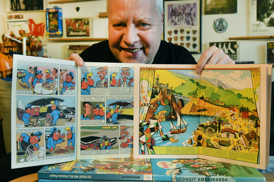 Thomas Wilde hält ein Mosaik-Comicheft mit den Digedags aus dem Jahr 1960 und ein Mosaikheft mit den Abrafaxen von 1976 in seinen Händen.
