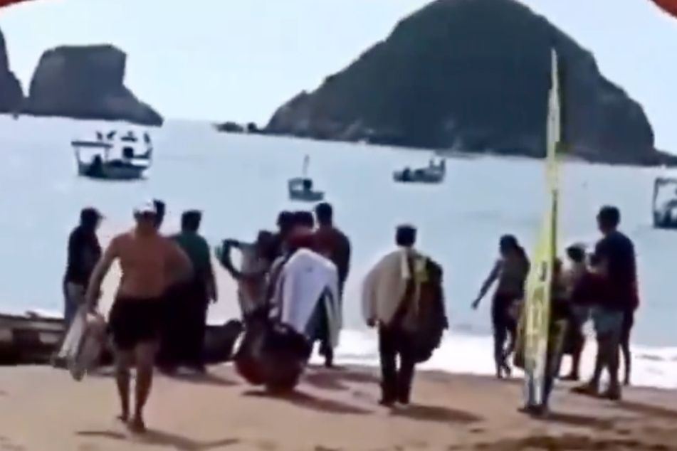 Rescuers carried the victim out of the water after she was attacked by a shark.
