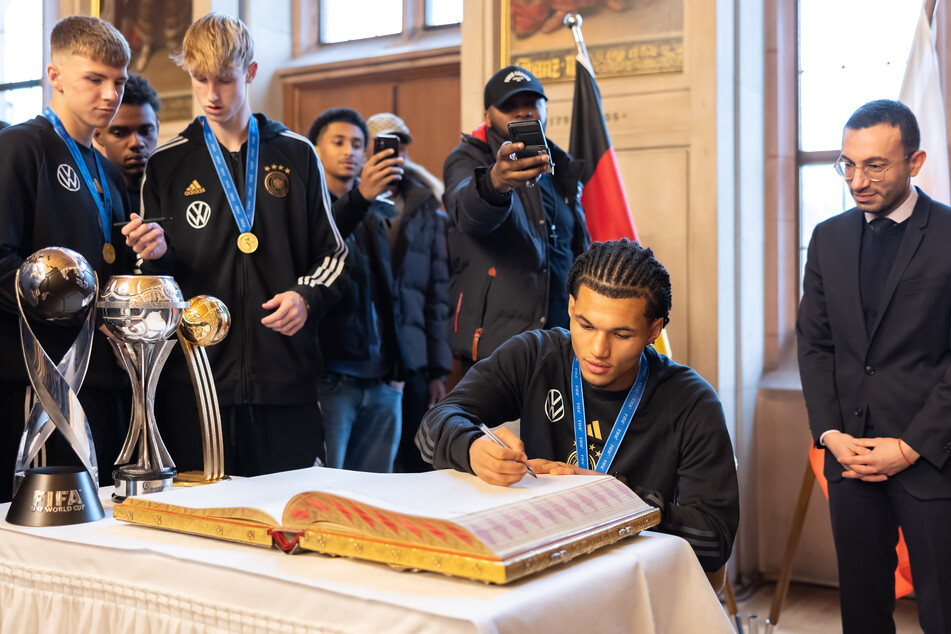 Nach dem WM-Triumph in Indonesien durften sich die Junioren-Weltmeister um Paris Brunner (schreibend am Tisch) in das Goldene Buch der Stadt Frankfurt eintragen.