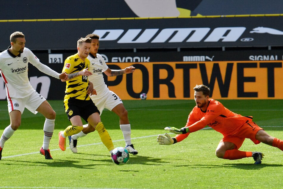 Eintracht Frankfurts Torhüter Kevin Trapp (r.) schnappt sich den Ball vor Borussia Dortmunds Kapitän Marco Reus (2.v.l.).
