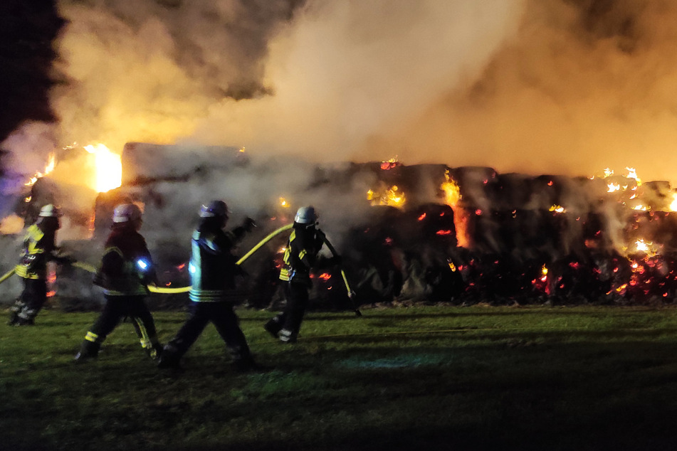 Dichter Rauch macht sich auf dem Feld breit, während Feuerwehrleute gegen die Flammen kämpfen.