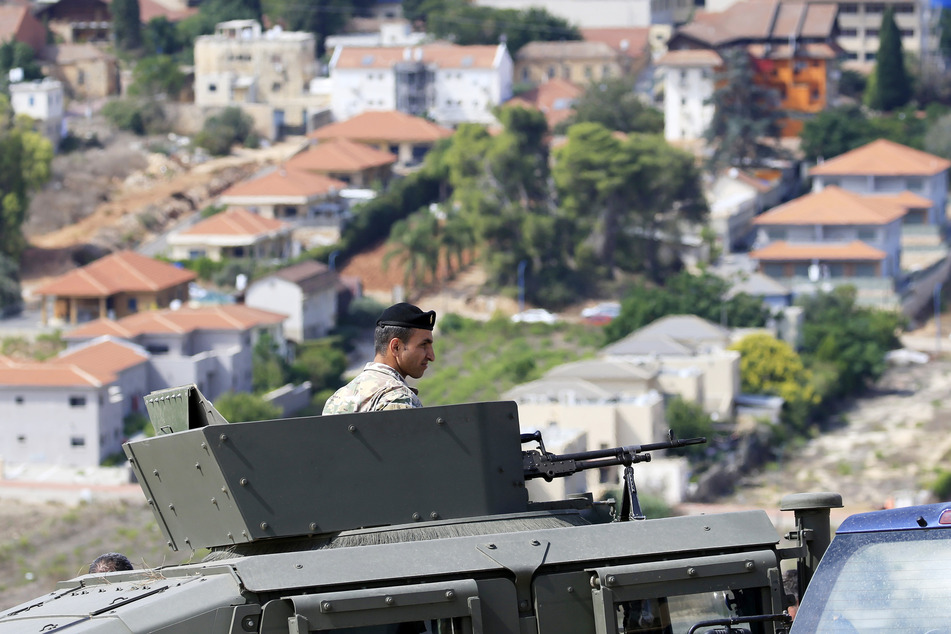Ein libanesischer Soldat schaut aus einem gepanzerten Fahrzeug auf die israelische Stadt Metulla.