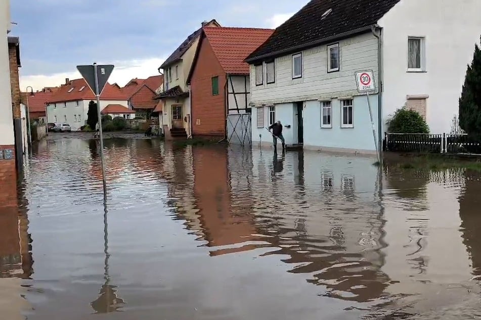 Wasser steht nach einem Unwetter in einer Straße in Anderbeck in der Gemeinde Huy im Landkreis Harz.