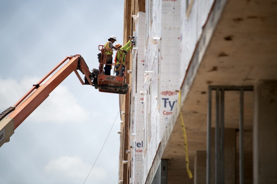 Construction workers put up house wrap during a heat wave in Houston, Texas.