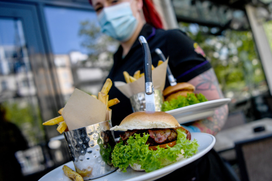 Eine Kellnerin serviert Essen im Hard Rock Cafe Berlin. (Symbolbild)