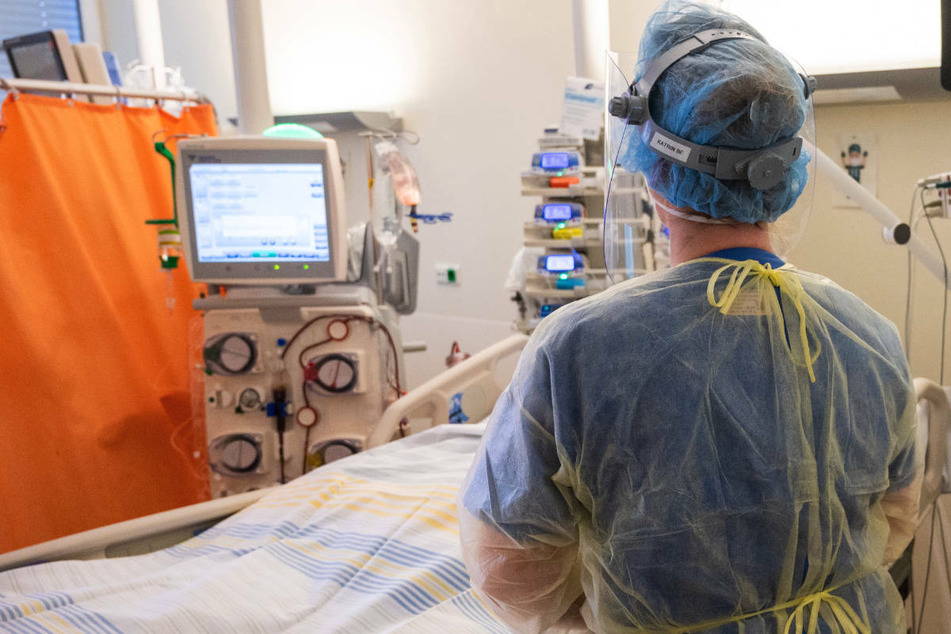 Ein Intensivpfleger versorgt einen Patienten mit einem schweren Covid-19 Krankheitsverlauf. Die Berliner Krankenhausgesellschaft warnt vor einer Überbelastung von Personal und Kliniken. (Archivfoto)