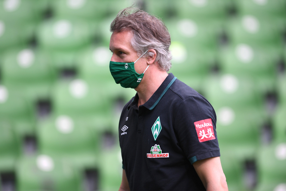 Werder Geschäftsführer Frank Baumann geht vor dem Spiel über den Rasen.