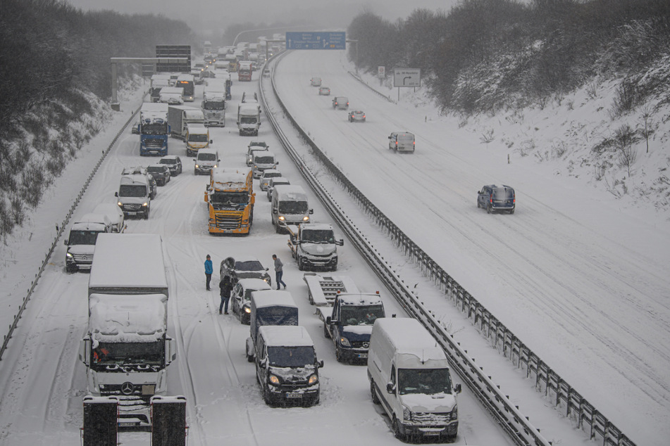 Autos und Lkw stehen auf der Autobahn 4 in Richtung Frankfurt bei Dresden durch Schneefall im Stau.