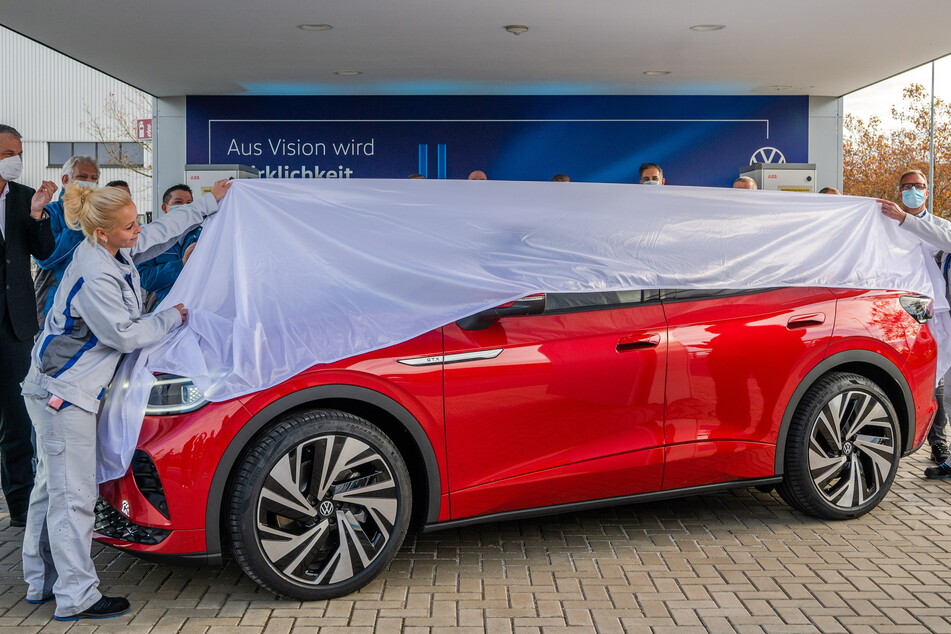 VW-Mitarbeiterinnen enthüllen das neue E-Auto.
