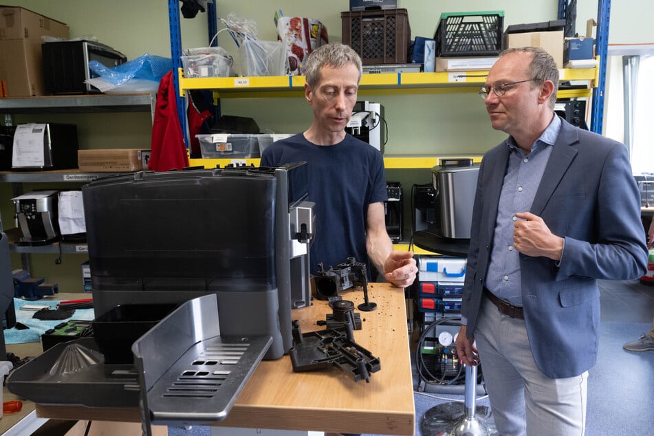 Sachsens Umweltminister Wolfram Günther (50, Grüne, r.) zu Besuch bei Servicetechniker Lothar Prohl in der Werkstatt der HSC HomeElectronic Service Center GmbH in Leipzig. Der Betrieb beteiligt sich am Programm für den Reparaturbonus.