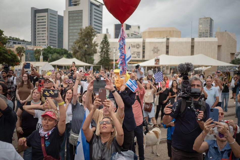 Menschen versammeln sich auf dem Geiselplatz in Tel Aviv, um das Waffenstillstandsabkommen zu feiern.