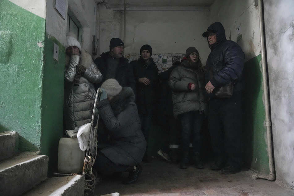 Menschen schützen sich vor Beschuss in einem Eingang zu einem Wohnhaus in Mariupol. Die Stadt gilt als Symbol des ukrainischen Widerstands - seit dem Beginn des Krieges im ostukrainischen Donbass 2014 wurden mehrere Versuche prorussischer Separatisten abgewehrt, die Stadt einzunehmen.