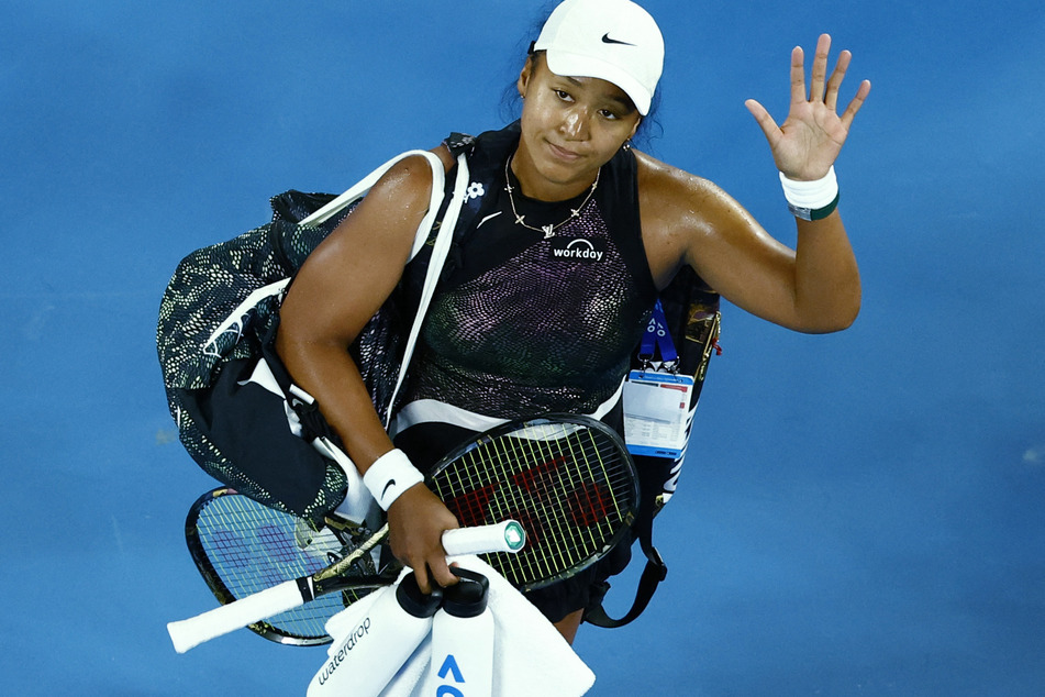 Japan's Naomi Osaka waves to the crowd after losing her first-round match against France's Caroline Garcia at the Australian Open on January 15, 2024.
