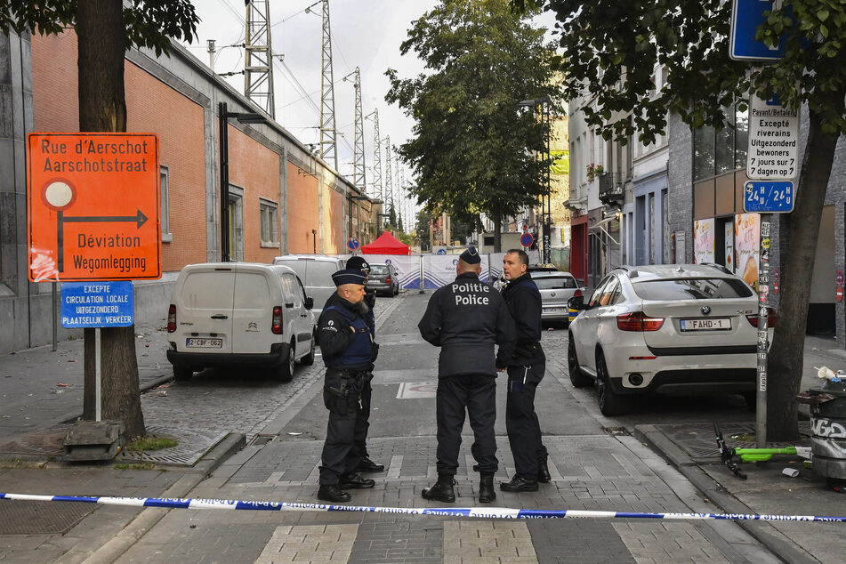 Belgische Polizeibeamte stehen in einem abgesperrten Bereich, in dem am Donnerstag, zwei Polizisten erstochen wurden.