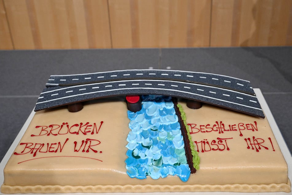 "Brücken bauen wir. Beschließen müsst ihr!" steht auf der Torte geschrieben.