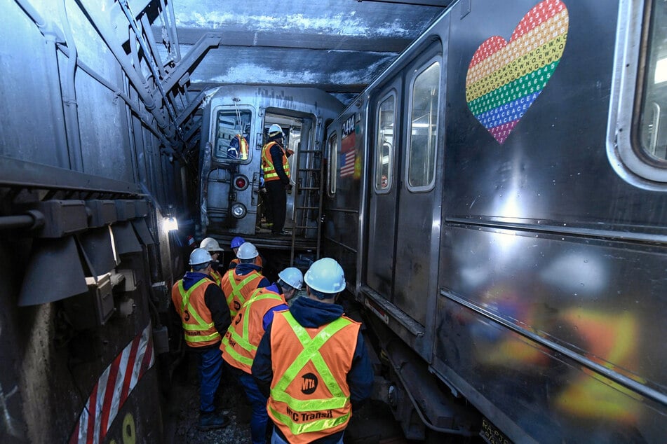 Einsatzkräfte überprüfen den Schauplatz der Entgleisung eines New Yorker U-Bahnwagens.