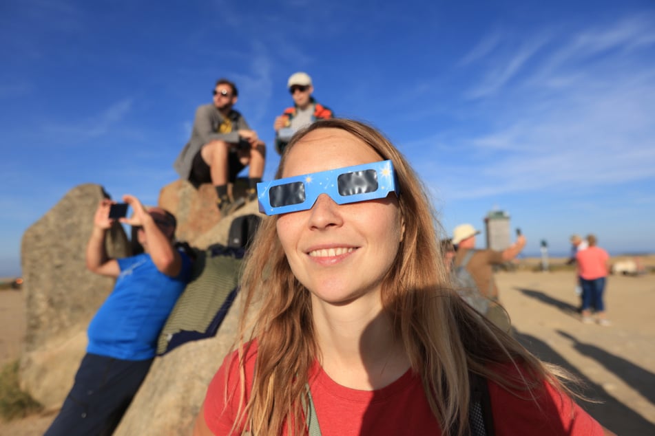 Kylie Wersinger beobachtet die partielle Sonnenfinsternis im Harz auf dem Brocken.