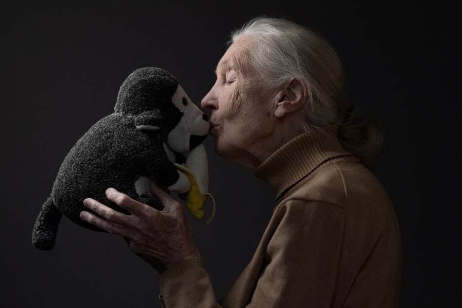 Jane Goodall poses with her mascot "Mr. H," a stuffed monkey, in Paris, France.