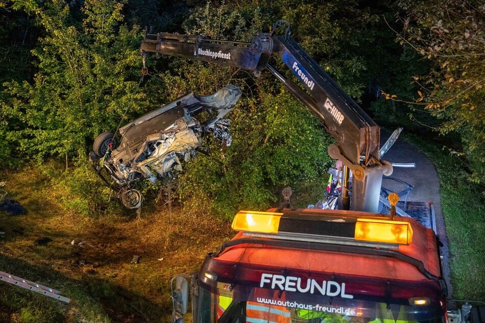 Das zweite Wrack-Teil wird mit einem Kran aus dem Gebüsch geborgen.