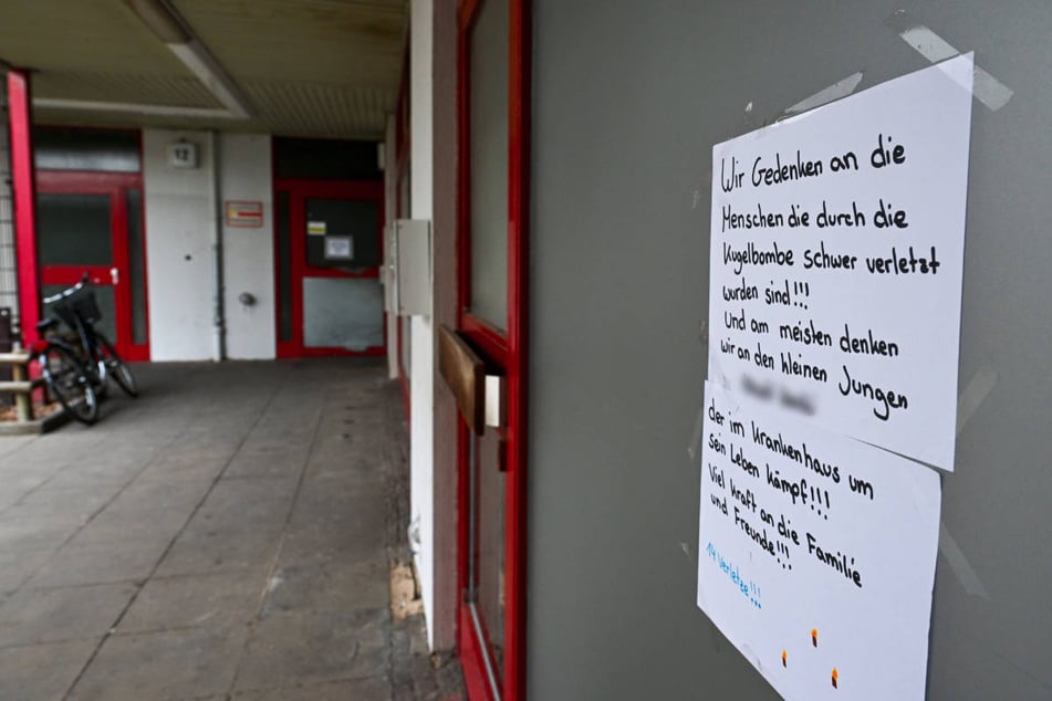 Nachbarn gedenken des schwer verletzten Jungen und der anderen, die bei der Explosion der Kugelbombe in der Wohnsiedlung am Emstaler Platz verletzt wurden.