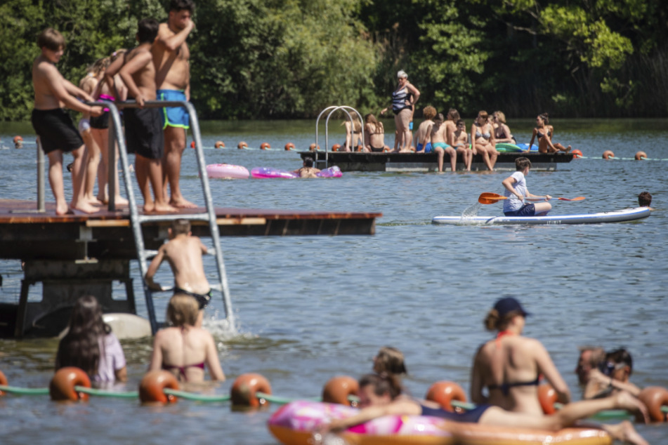 Menschen genießen den sonnigen Tag am Badesee in Plüderhausen.