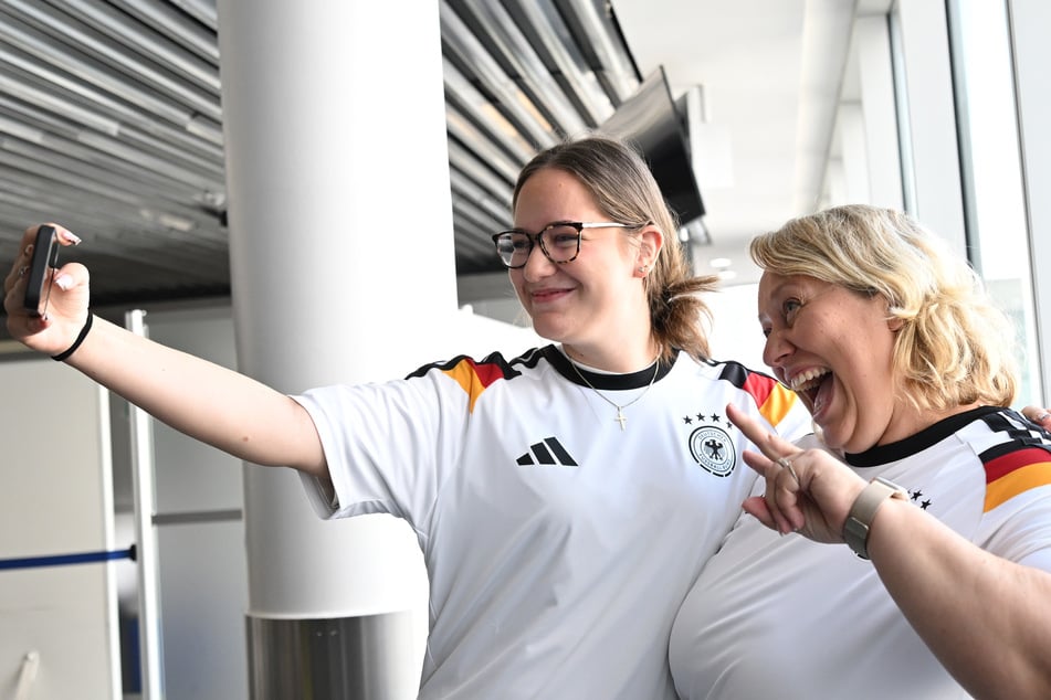 Zwei Passagierinnen von Lufthansa-Flug LH434 posieren mit ihren neuen Deutschland-Trikots. Sie reisen im selben Flugzeug wie die Nationalmannschaft nach Chicago.
