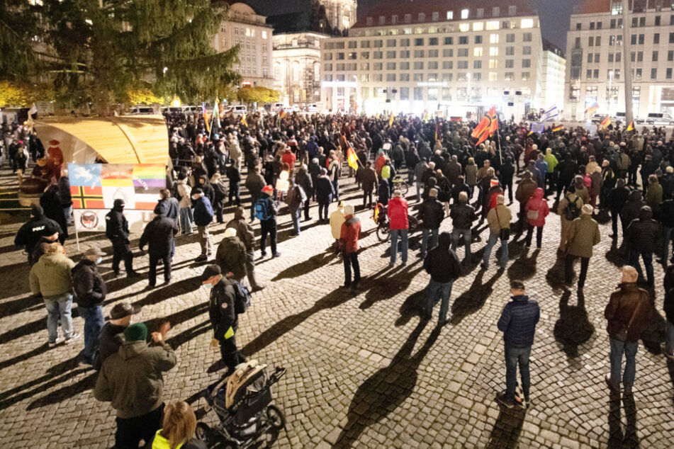 Participants stand on the Altmarkt in front of the Kreuzkirche during a demonstration of the Pegida movement in Dresden.