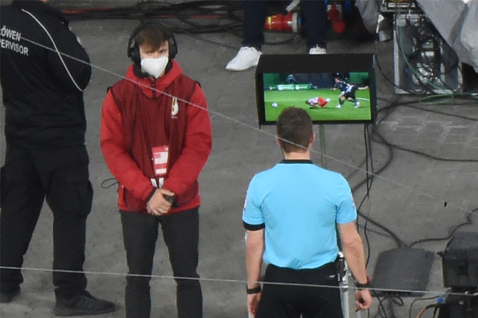 Schiedsrichter Felix Brych (r.) schaut sich beim DFB-Pokal-Spiel Leipzig gegen Union Berlin im April 2022 den Videobeweis (VAR) an.