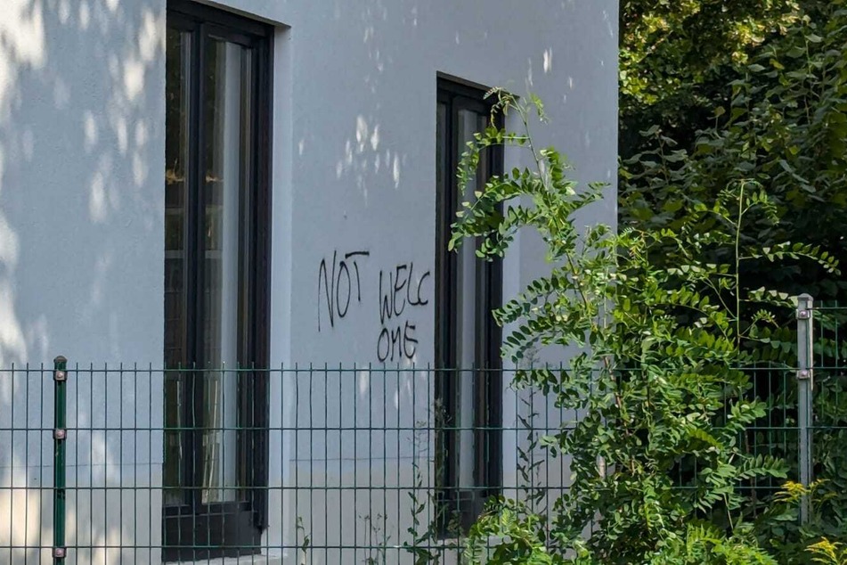 An einer weißen Wand wurde "Not welcome" aufgesprüht. Dies gilt höchstwahrscheinlich den Flüchtlingen, die hier bald wohnen sollen.