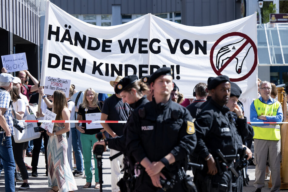 Teilnehmer einer Demonstration protestieren gegen die Lesung vor der Stadtteilbibliothek.