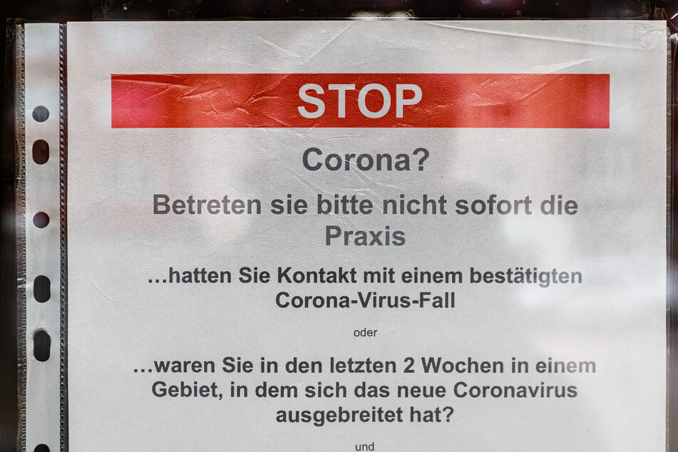Ein Aushang an einer Arztpraxis bittet Patienten mit Verdacht auf eine Covid-19 Erkrankung die Praxis nicht zu betreten.