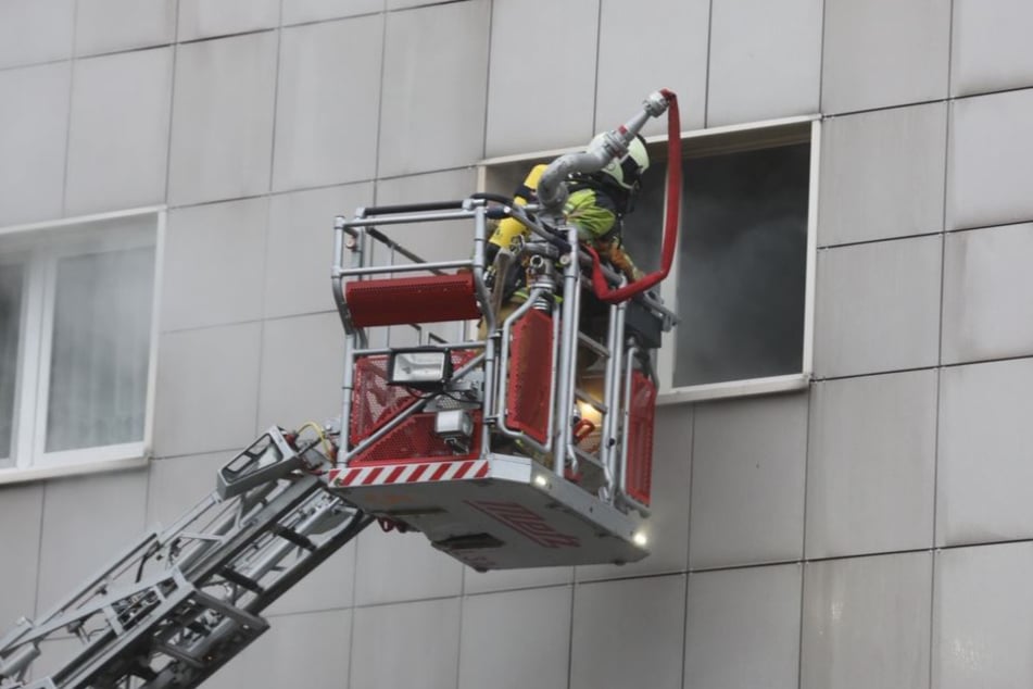Die Feuerwehr bekämpft den Brand durchs Fenster.